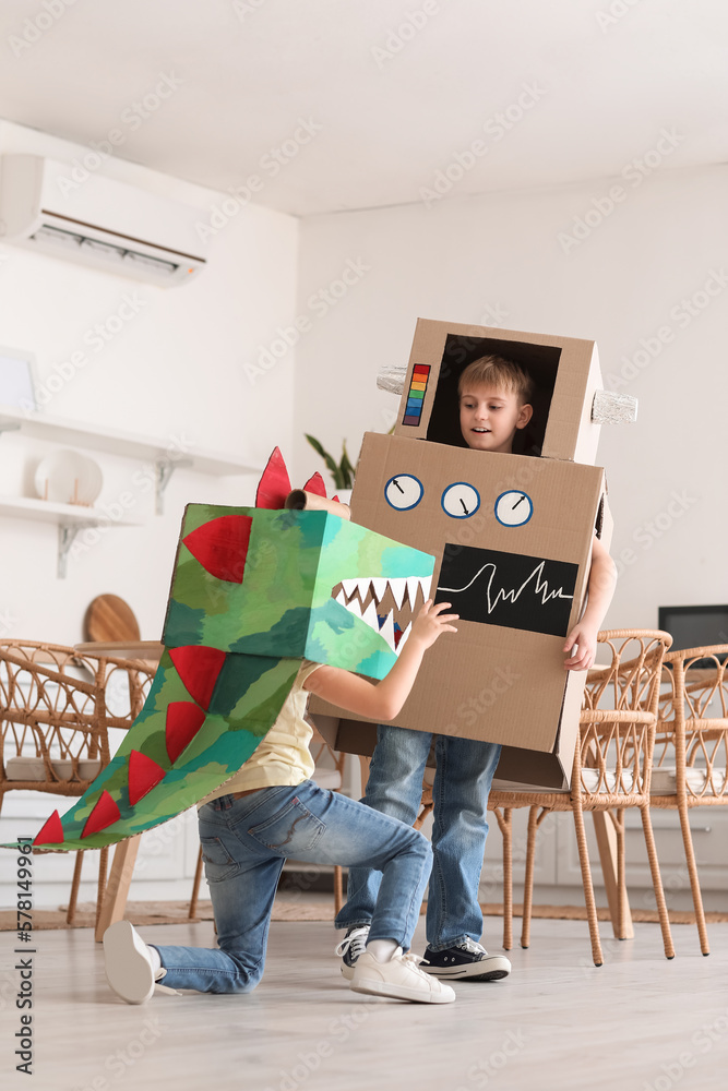 Little children in cardboard costumes playing in kitchen