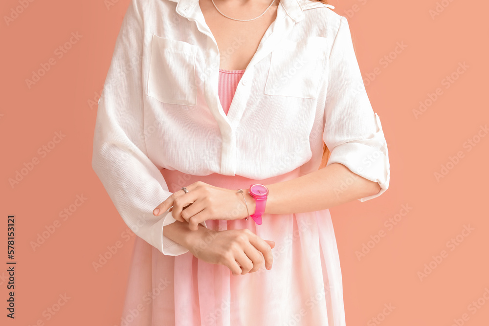 Woman with stylish wristwatch on pink background, closeup