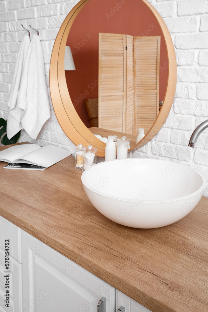 Sink with bath accessories on table in bathroom