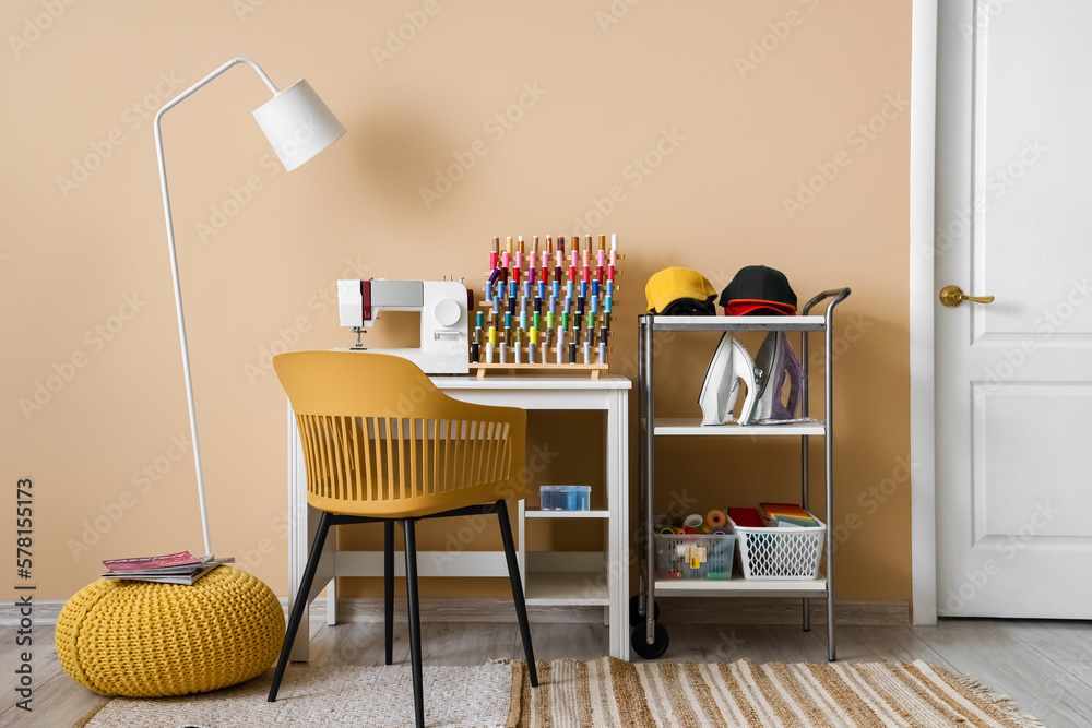 Interior of modern atelier with tailors workplace and shelving unit