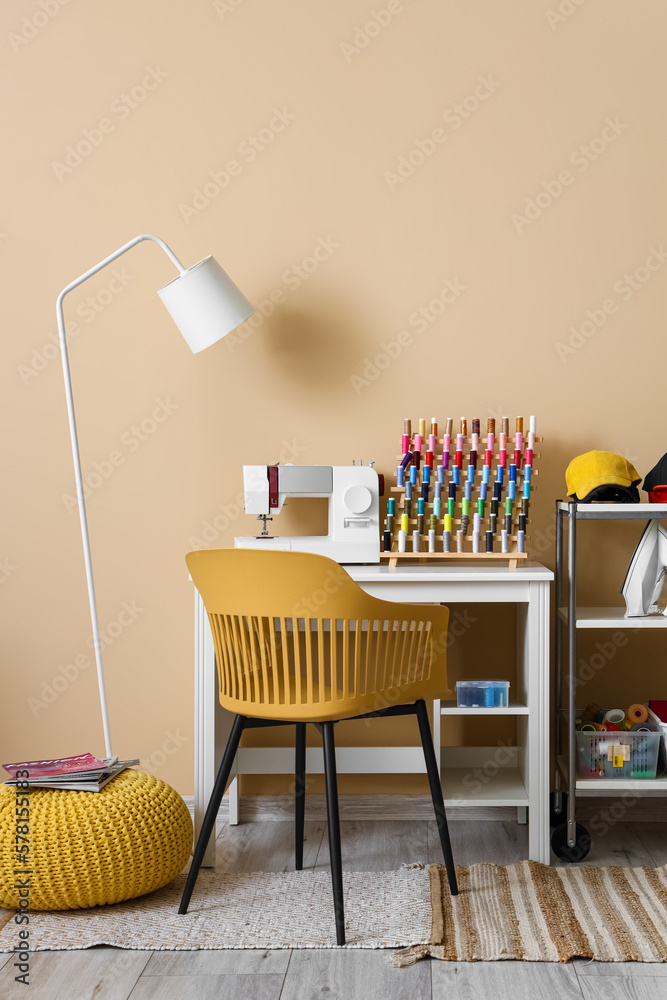 Interior of modern atelier with tailors workplace and shelving unit