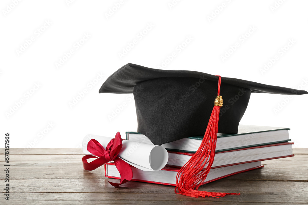 Graduation hat with diploma and books on wooden table against white background