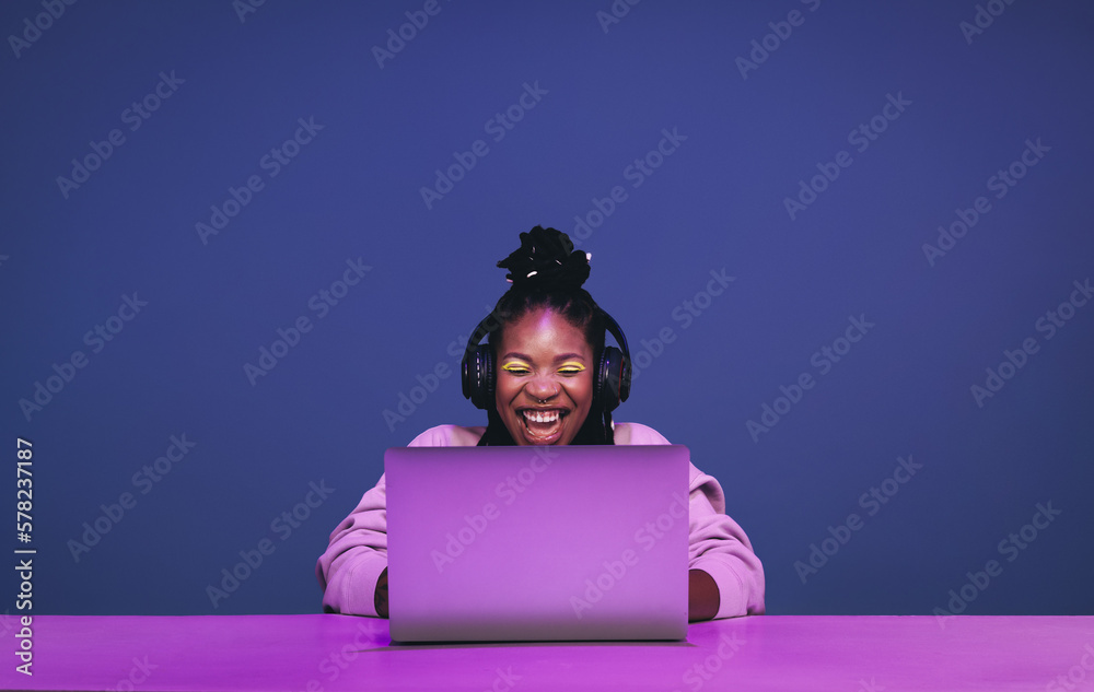 Cheerful female gamer winning an online game on a laptop