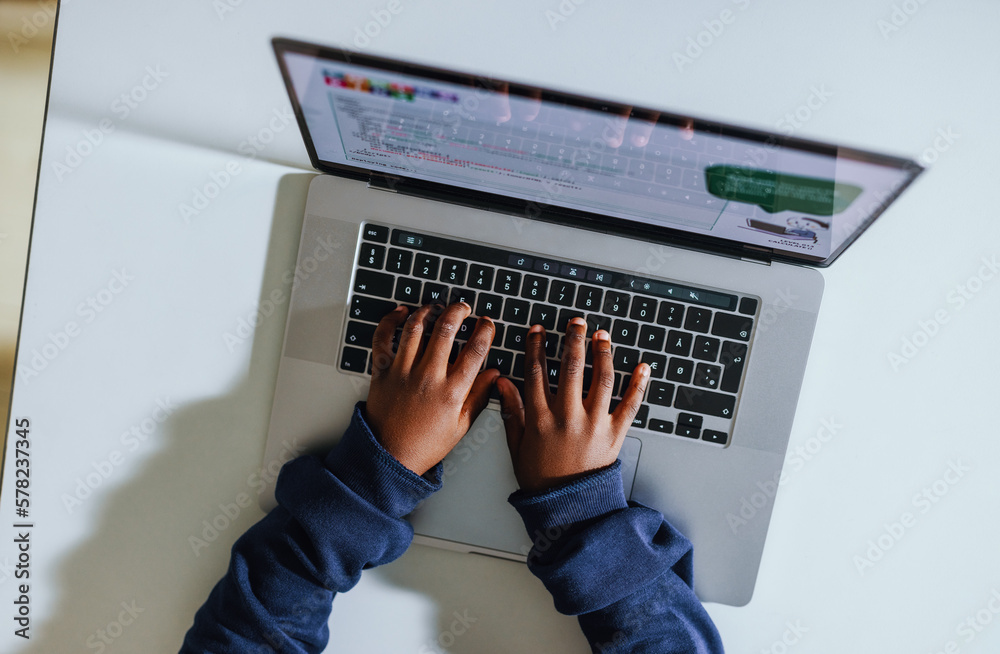 Young kid coding on a laptop in a computer science class