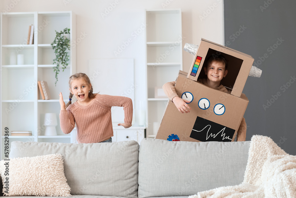 Little girl and her brother in cardboard robot costume at home