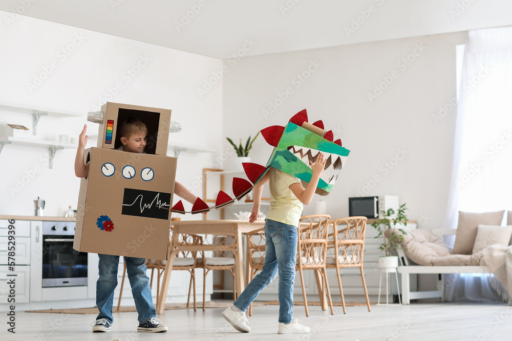 Little children in cardboard costumes playing in kitchen