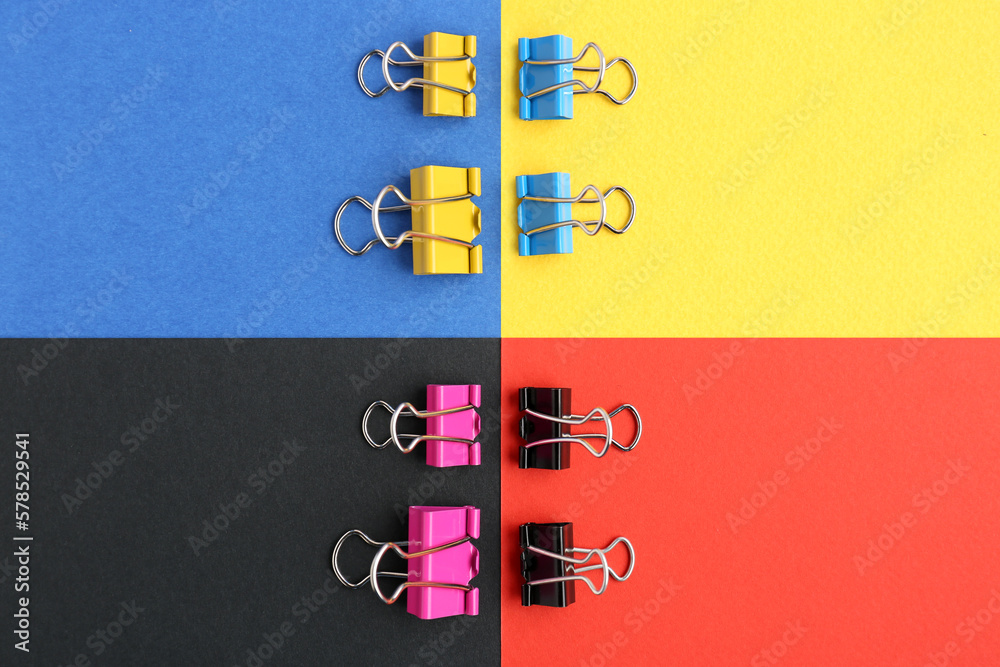 Composition with binder clips on color background