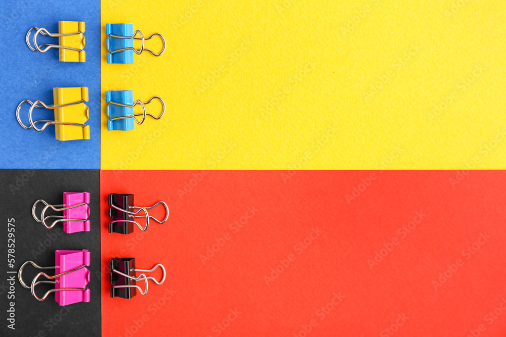 Composition with binder clips on color background