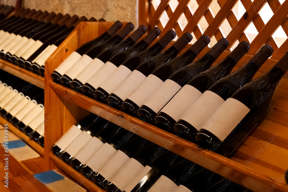 Wooden storage stand with bottles of wine in store, closeup