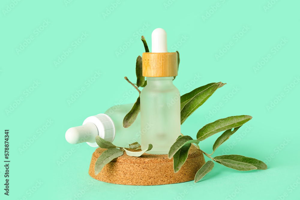 Bottles with olive essential oil on color background