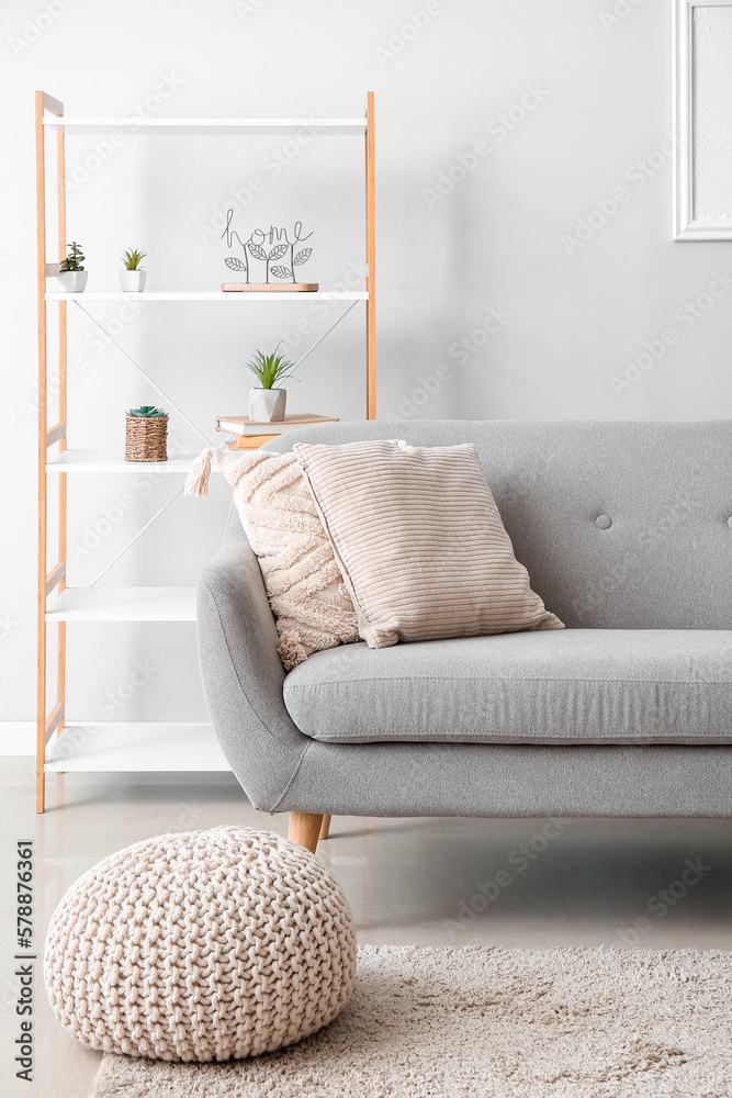 Interior of modern living room with soft pillows on grey sofa