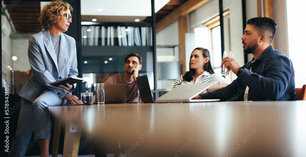 Business team discussing a project in a meeting. Group of business people sitting and talking in a b