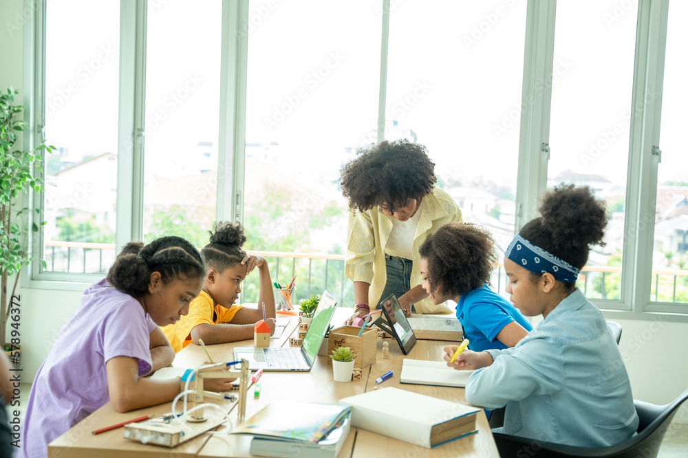 Happy school children using digital tablet in classroom at school,Black school student learning onli