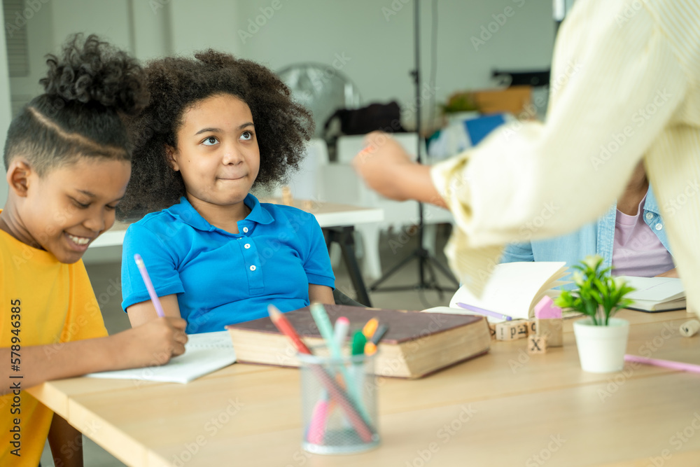 Black girl are taking test in elementary classroom school with diverse group of bright children work