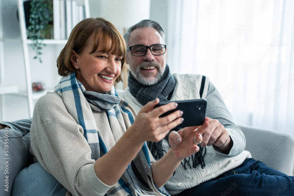 Caucasian senior couple video call with family in living room at home. 