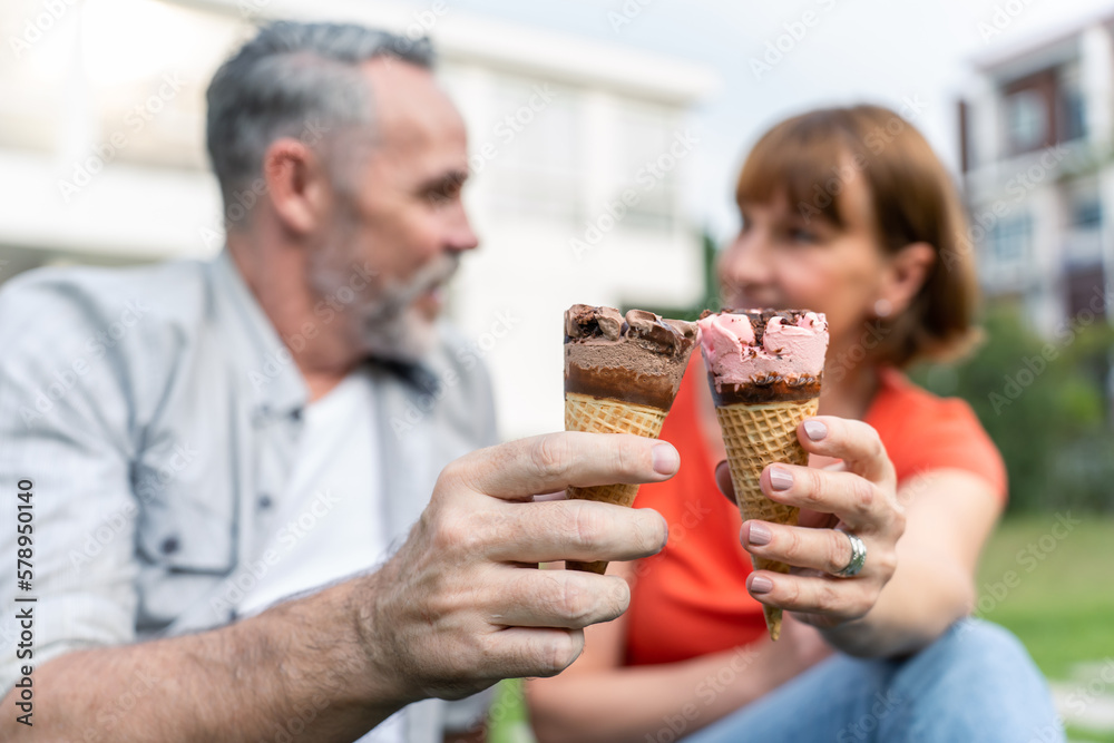 Caucasian senior man and woman having a picnic outdoors in the garden. 