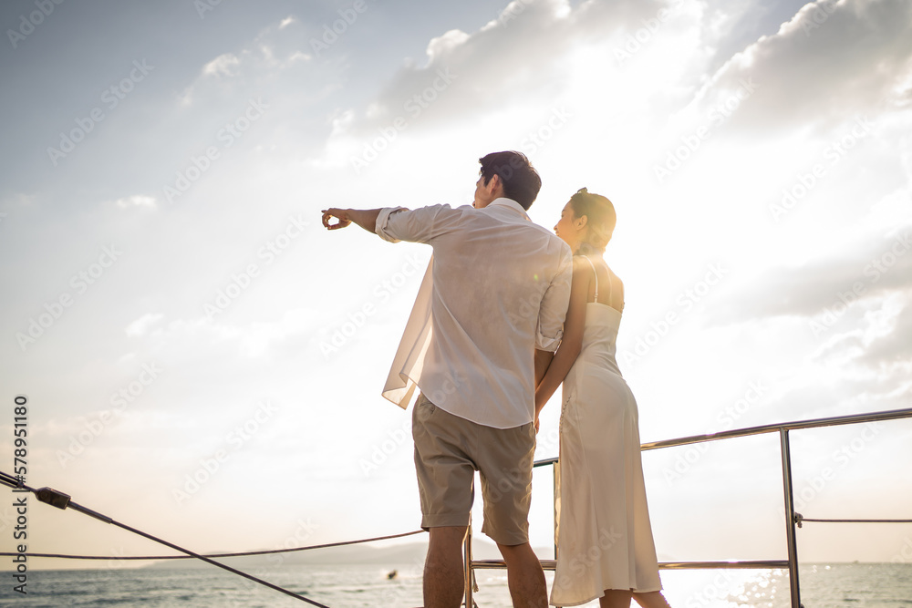 Asian young romantic couple looking at beautiful view during yachting. 