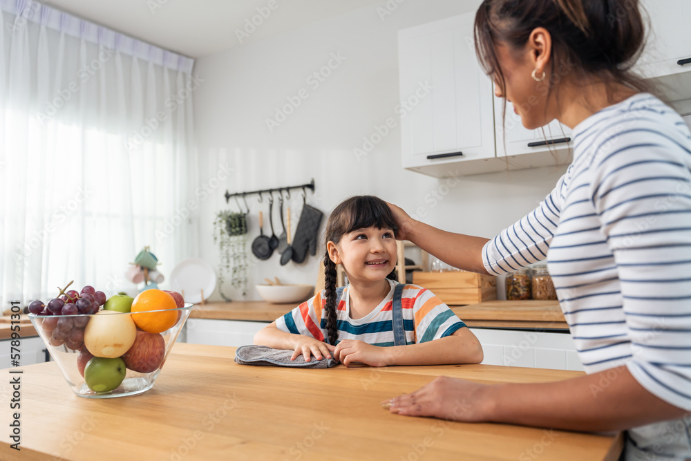 Caucasian beautiful mother cleaning house with young kid daughter. 