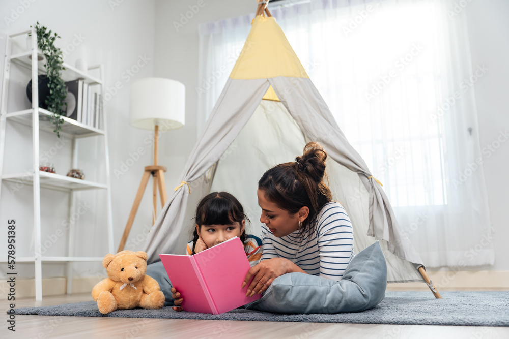 Caucasian mother read story and telling a fairy tale to young daughter. 