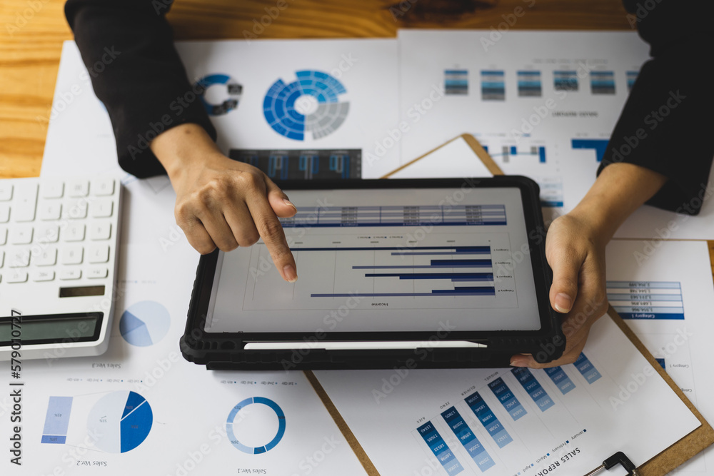 Businesswoman analyzing financial statistics displayed on the tablet screen, working data document g