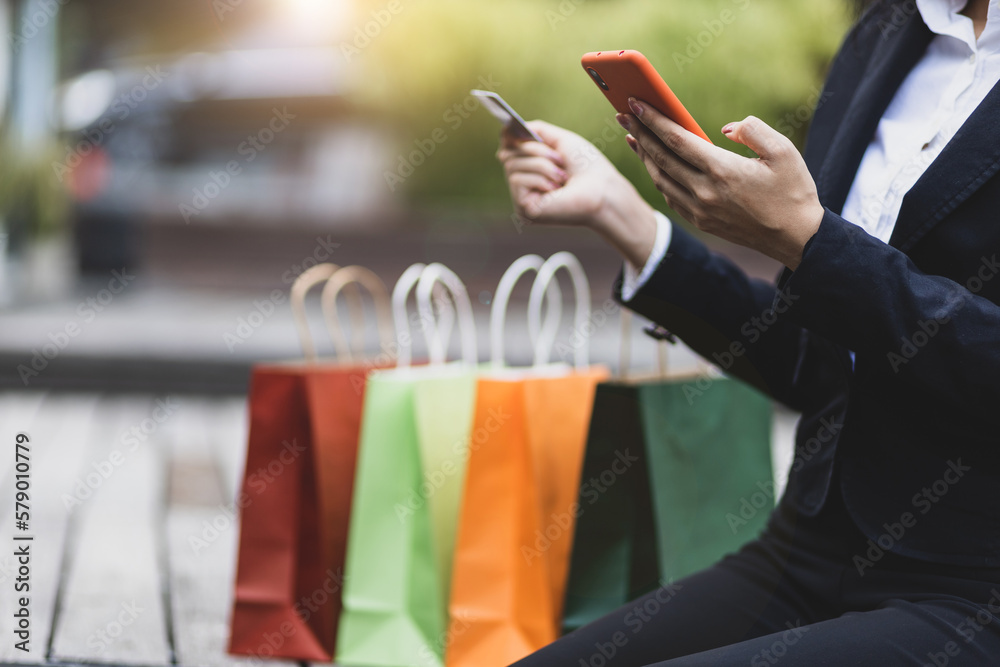 Beautiful woman shopping online on smartphone using credit card.