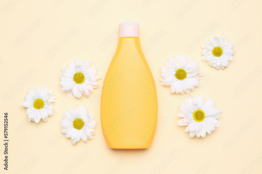 Bottle of cosmetic product and chamomile flowers on color background