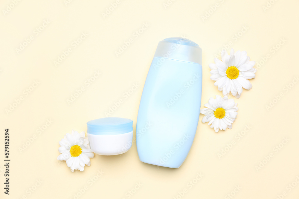 Cosmetic products with chamomile flowers on color background