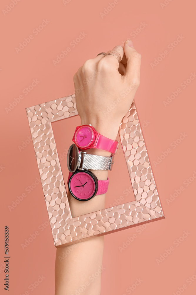 Woman with stylish wristwatches and frame on pink background