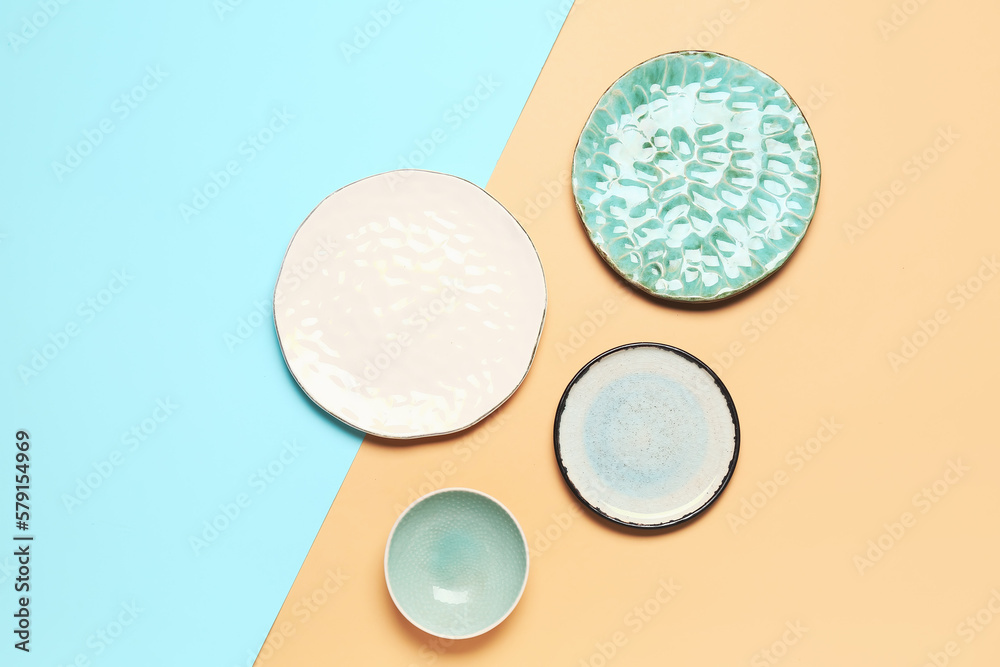 Composition with clean ceramic plates on blue and beige background