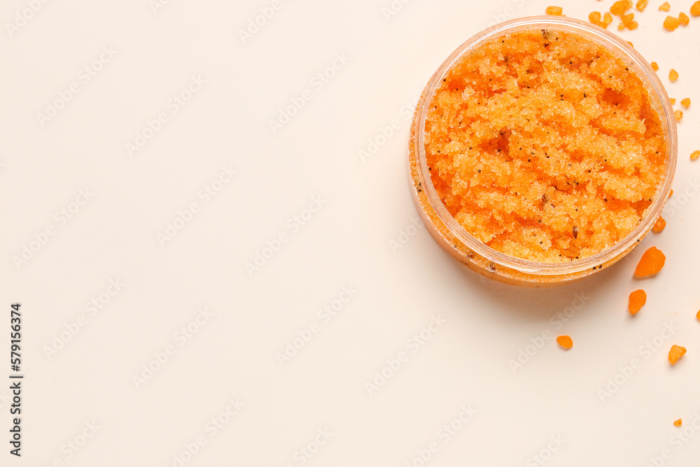 Jar of body scrub and sea salt on light background