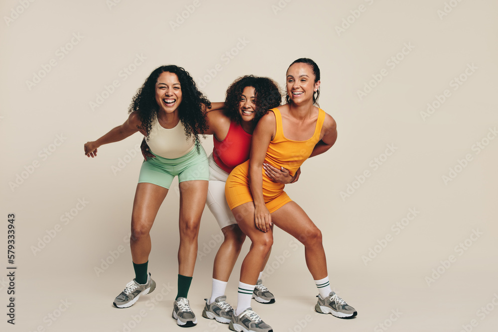 Fitness fun: Group of happy female athletes laughing in sportswear