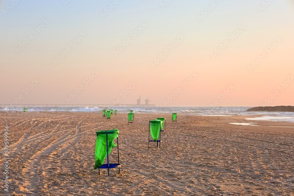 Garbage containers on sand near sea