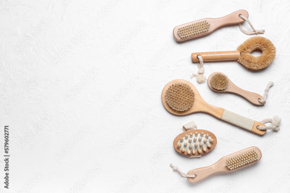 Set of different massage brushes on light background