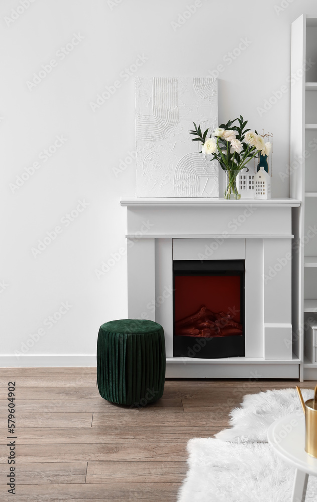 Interior of living room with flowers in vase on fireplace