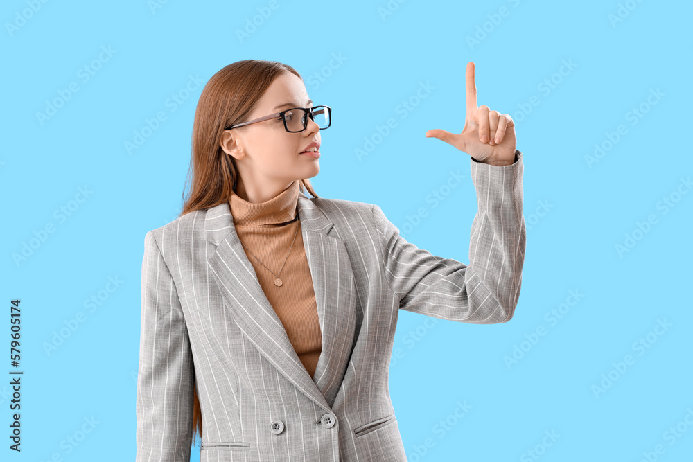 Young businesswoman showing loser gesture on blue background