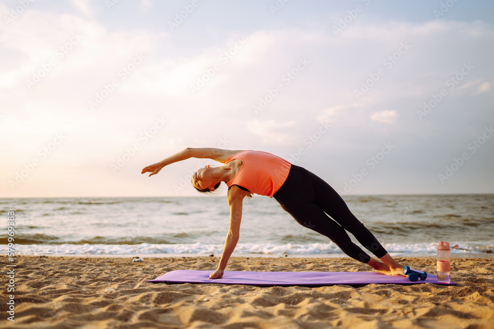 Young woman doing exercises outdoors in the morning. Active life, sports training, fitness, yoga,  h