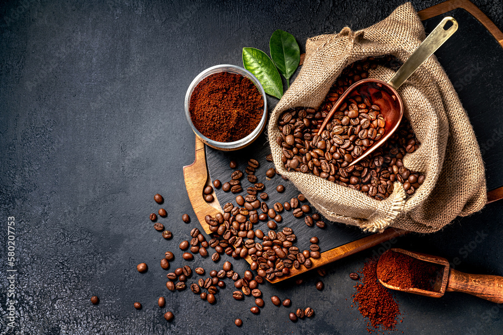 Scoop of coffee beans in a bag on dark board. Top view of ground coffee in a cup and instant coffee 