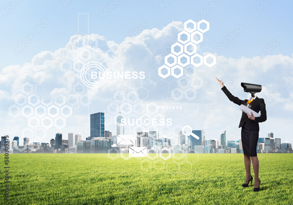 Camera headed woman standing on green grass against modern cityscape