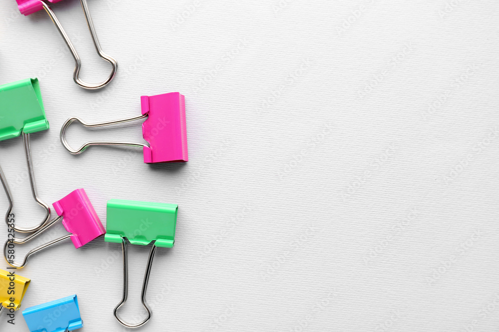 Colorful binder clips on grey background