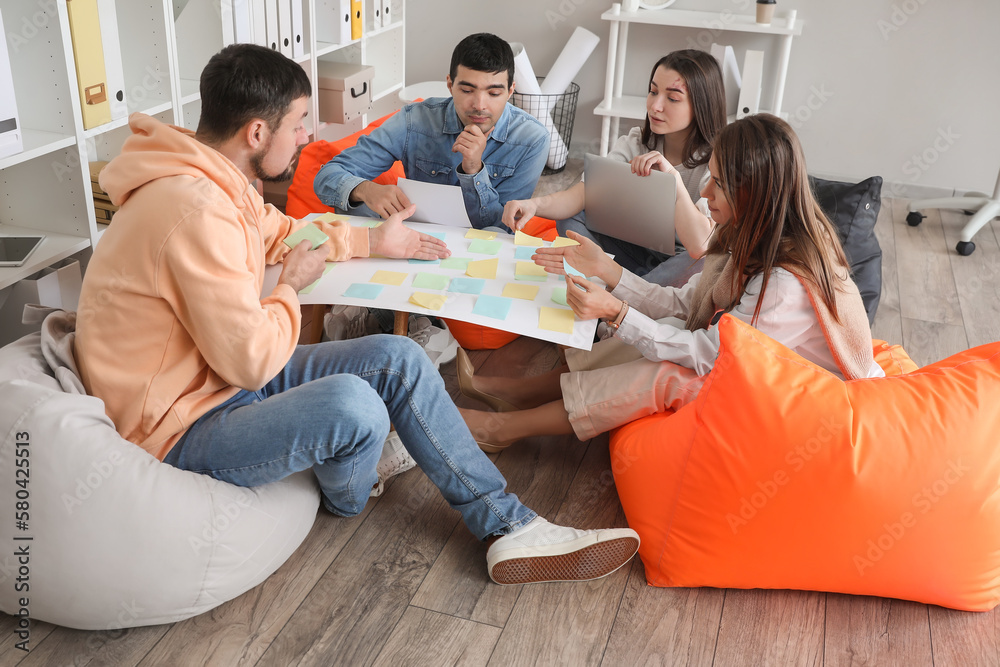 Team of people with sticky notes working on business plan in office