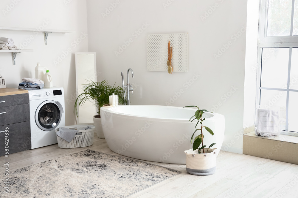 Interior of bathroom with bathtub, houseplants and pegboard