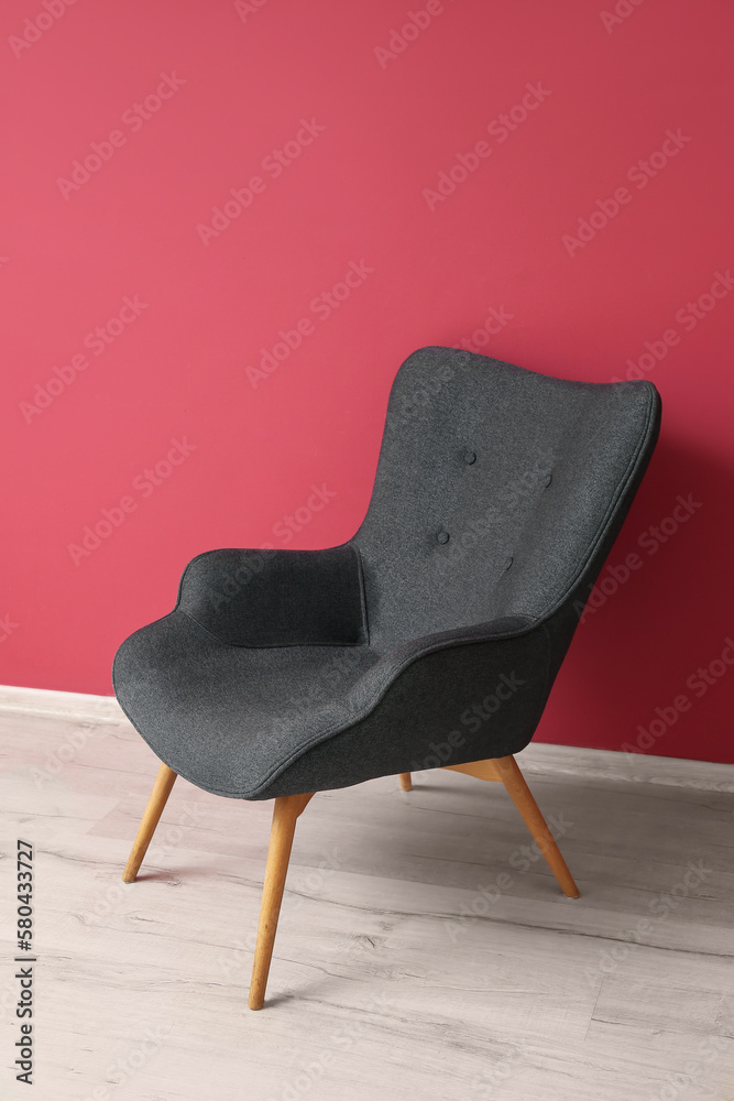 Black armchair near red wall in room