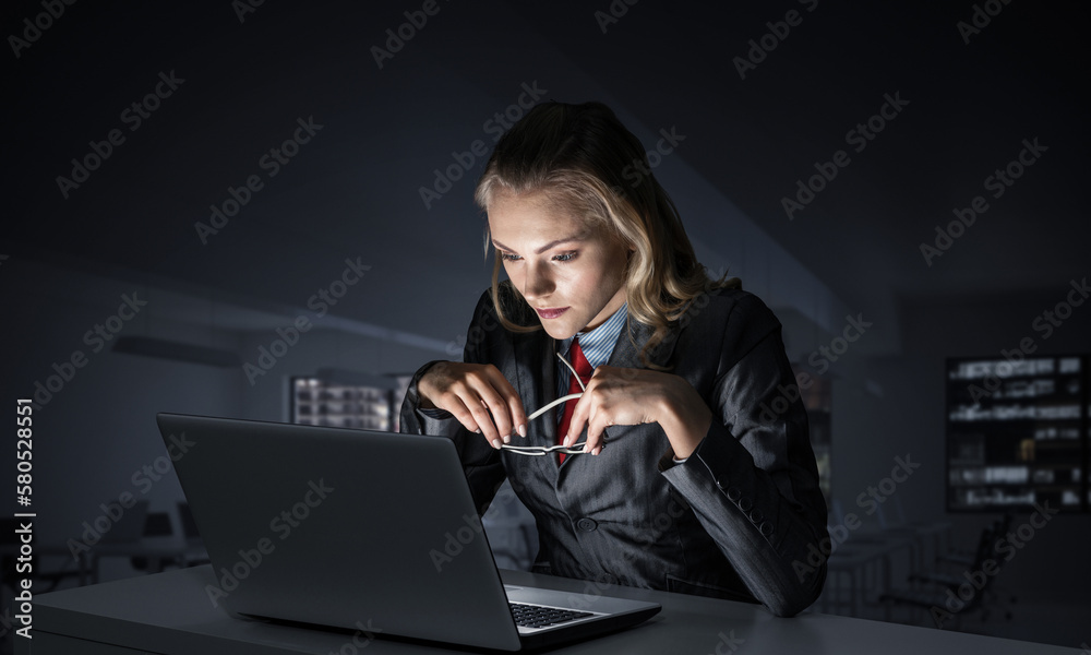 Attractive young woman in glasses sitting at desk