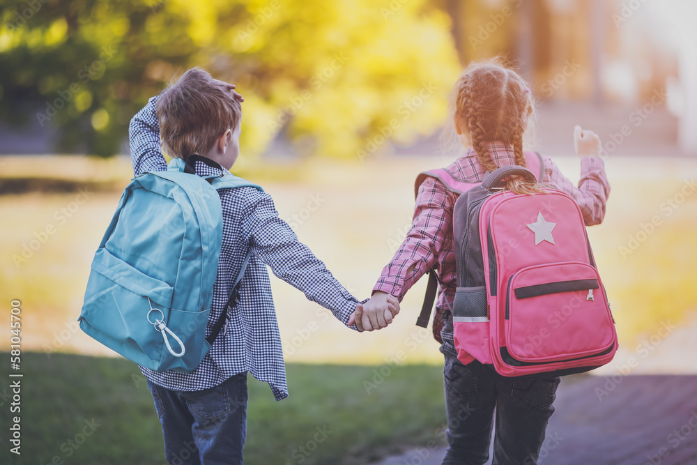 Girl and boy going to the school holding hands to study at it.