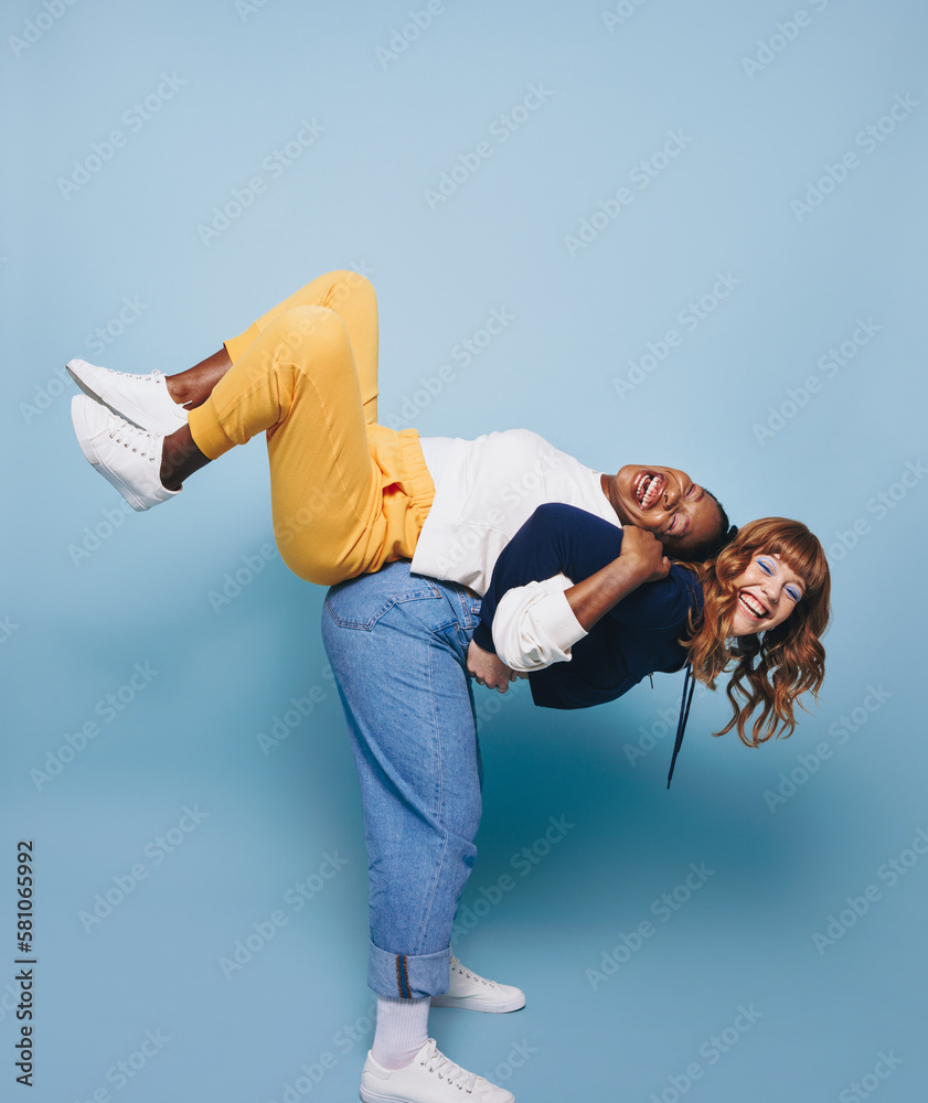 Woman carrying her friend on her back in a studio