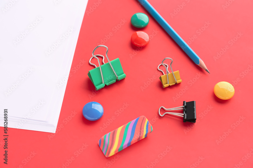 Set of stationery with binder clips on red background