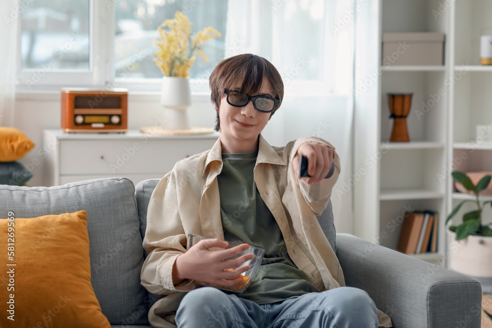 Teenage boy in 3D glasses watching TV at home