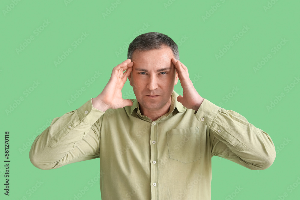 Stressed mature man in shirt on green background