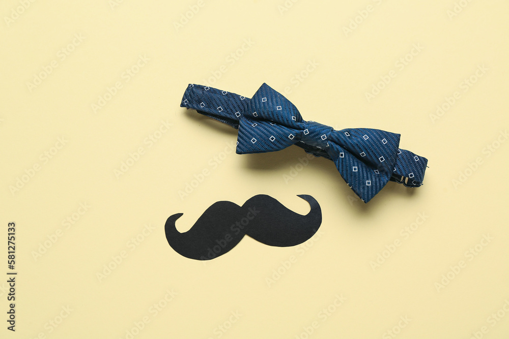 Male bow tie and paper mustache on color background