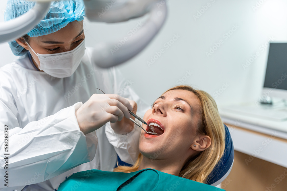 Female dentist examine tooth to Caucasian girl at dental health clinic. 